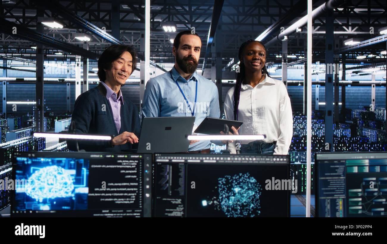 Happy high tech server room team members collaborating on neural network software development. Stock Photo