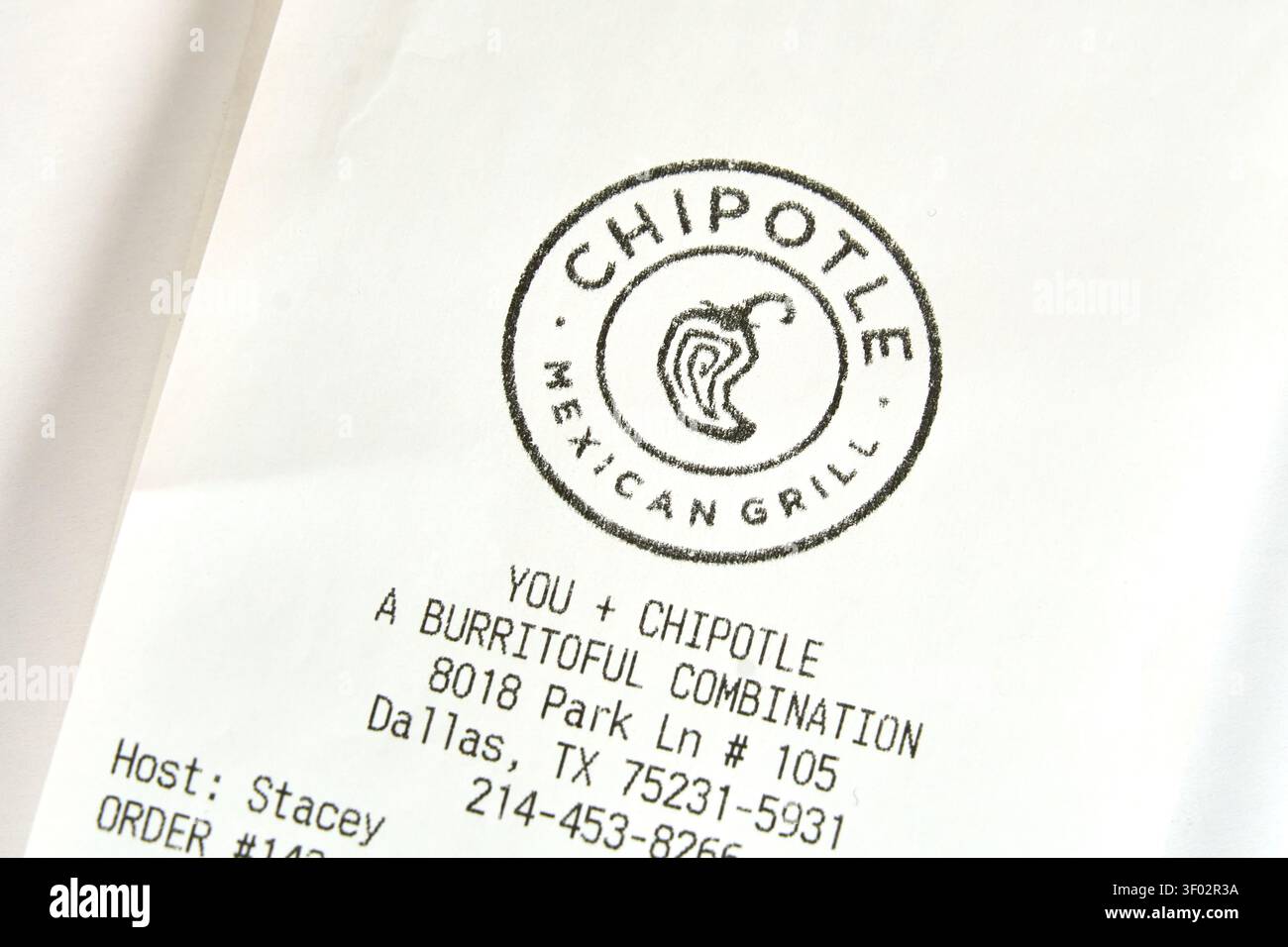 DALLAS, TX, USA - FEBRUARY 16, 2024: A close-up of a Chipotle Mexican Grill receipt printed on white paper. The receipt displays the logo of Chipotle, Stock Photo