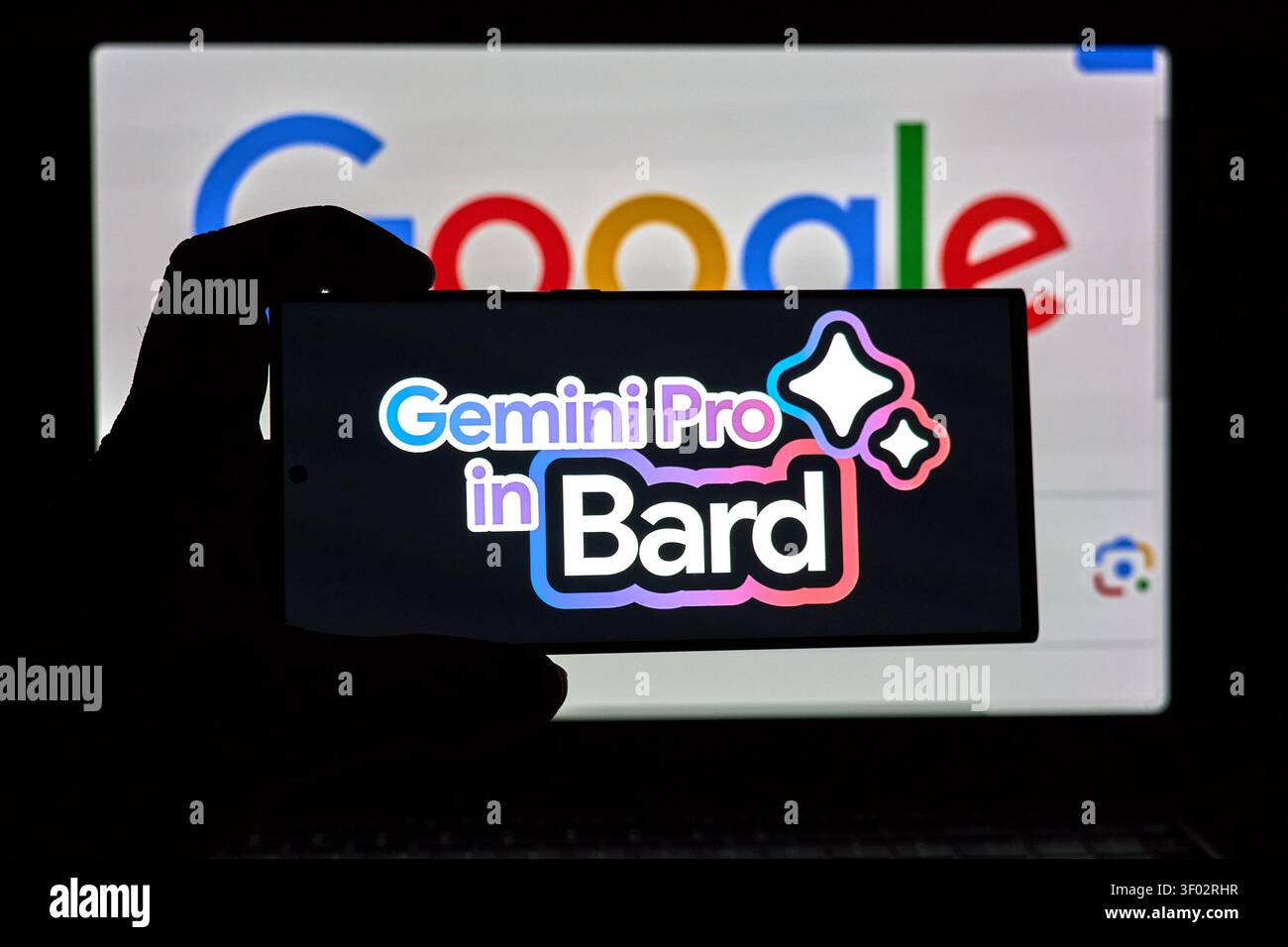 DALLAS, TX, USA - FEBRUARY 16, 2024: A silhouette of a hand is seen holding a smartphone which displays the text 'Gemini Pro in Bard' prominently on i Stock Photo