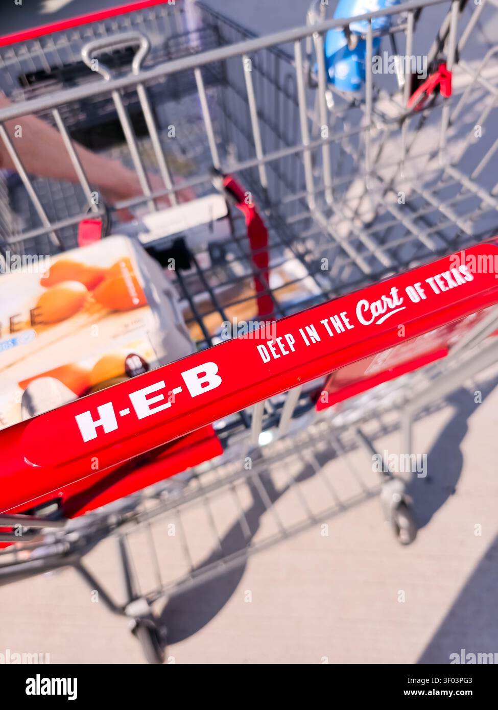 PLANO, TX, USA - JULY 05, 2026: An H-E-B shopping cart prominently displays branding text 'DEEP IN THE cart OF TEXAS'. The cart contains an egg carton Stock Photo