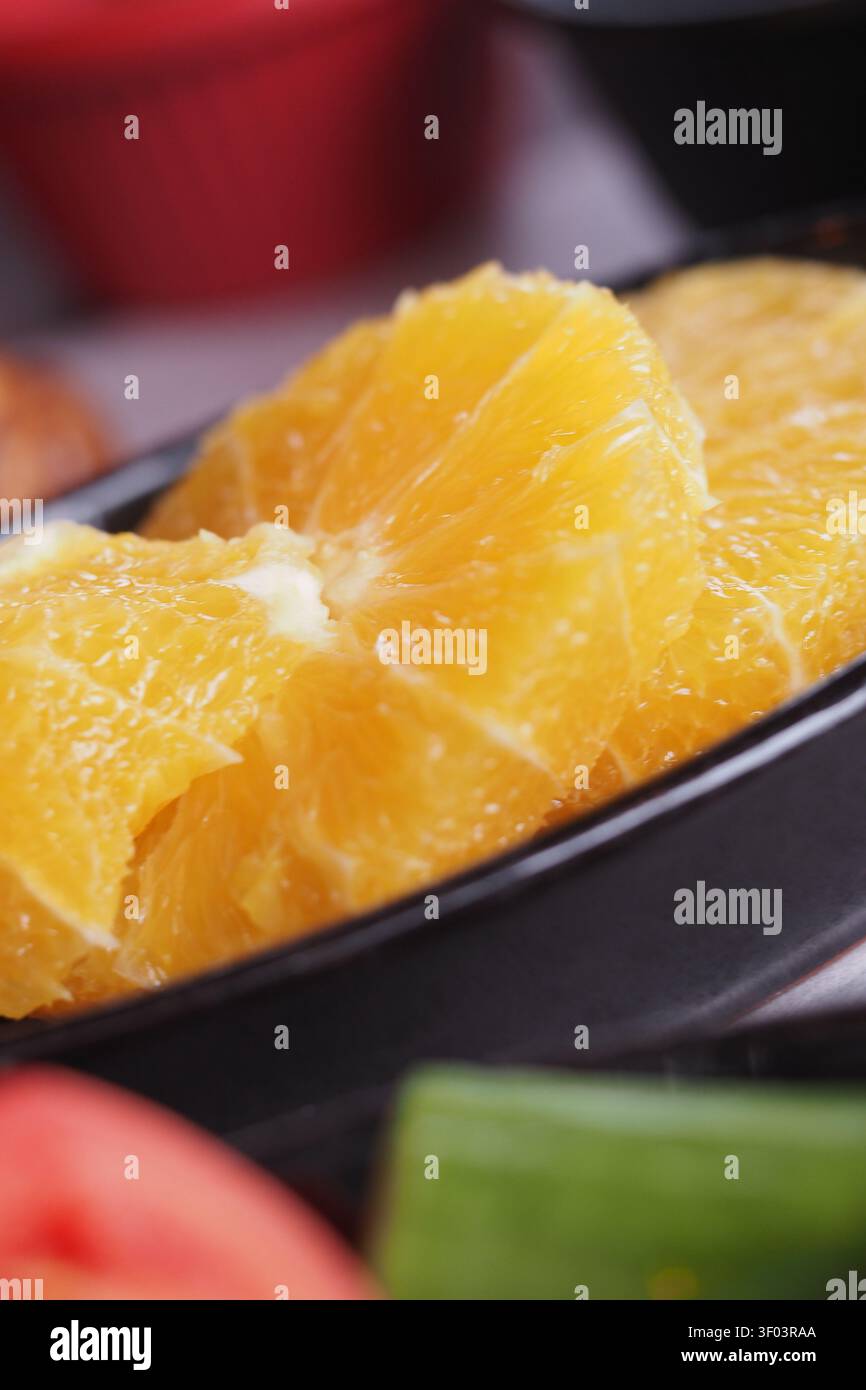 Fresh orange slices on a black plate ready for serving Stock Photo