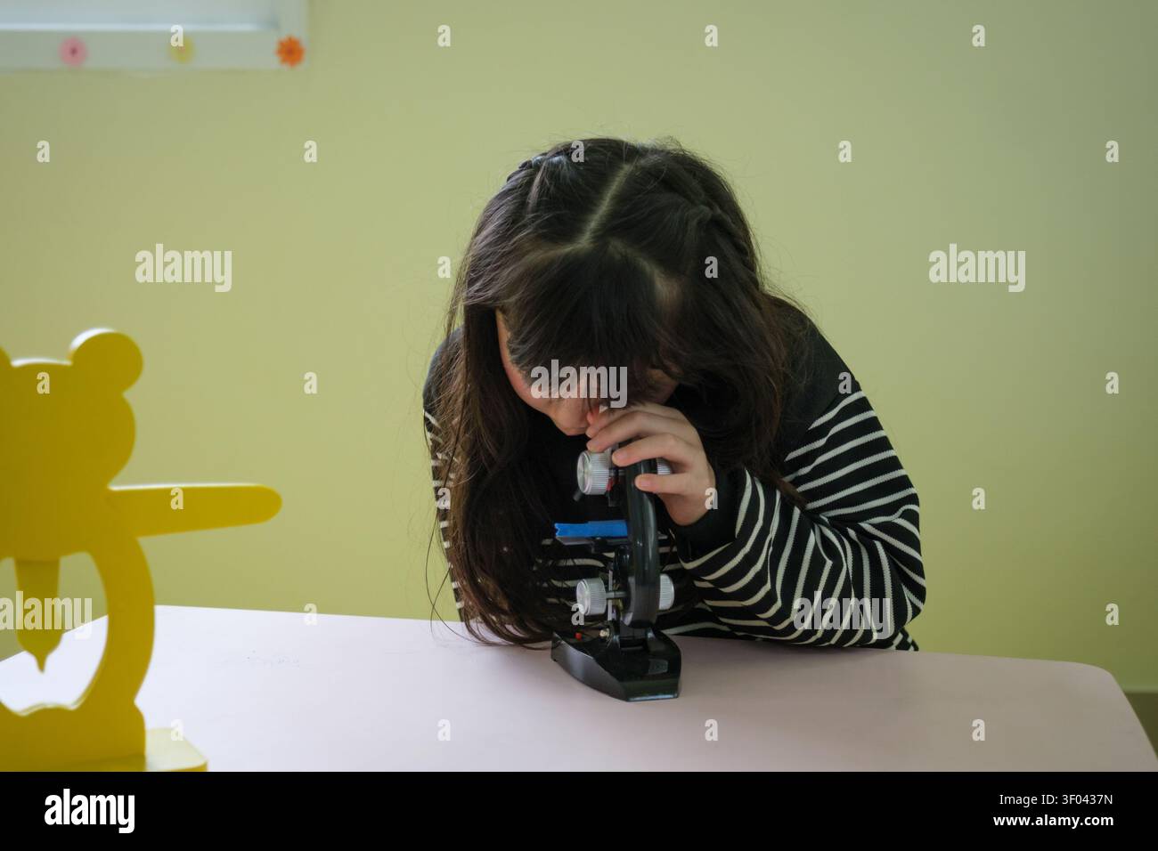 The students are having fun looking through the microscope. Stock Photo