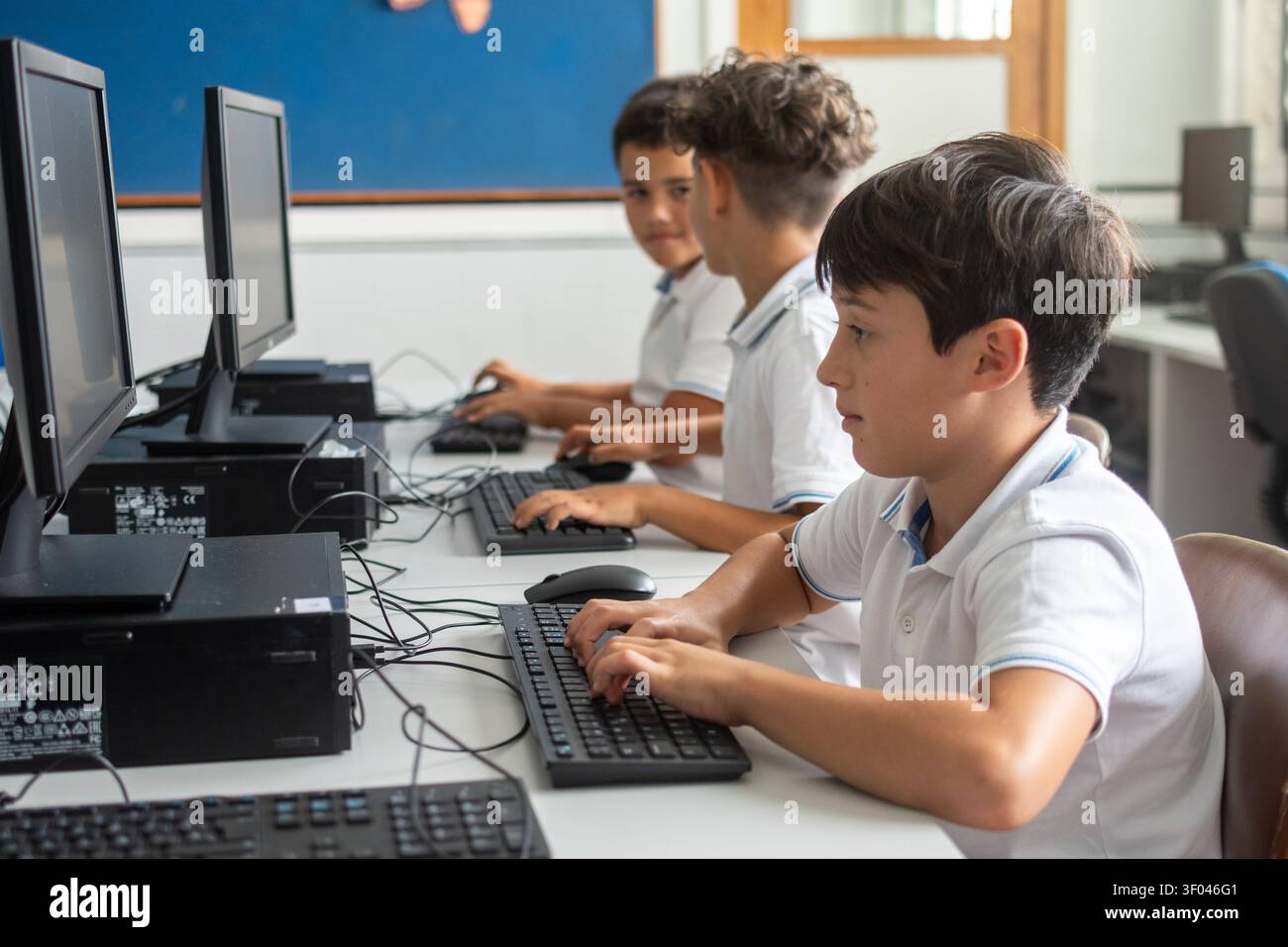 Elementary School Boys Using Desktop Computers During an Information Technology Class Stock Photo