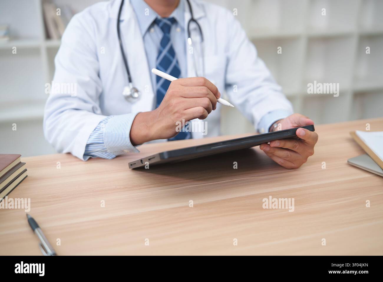 Healthcare Professional Using Tablet for Digital Record Keeping Stock Photo