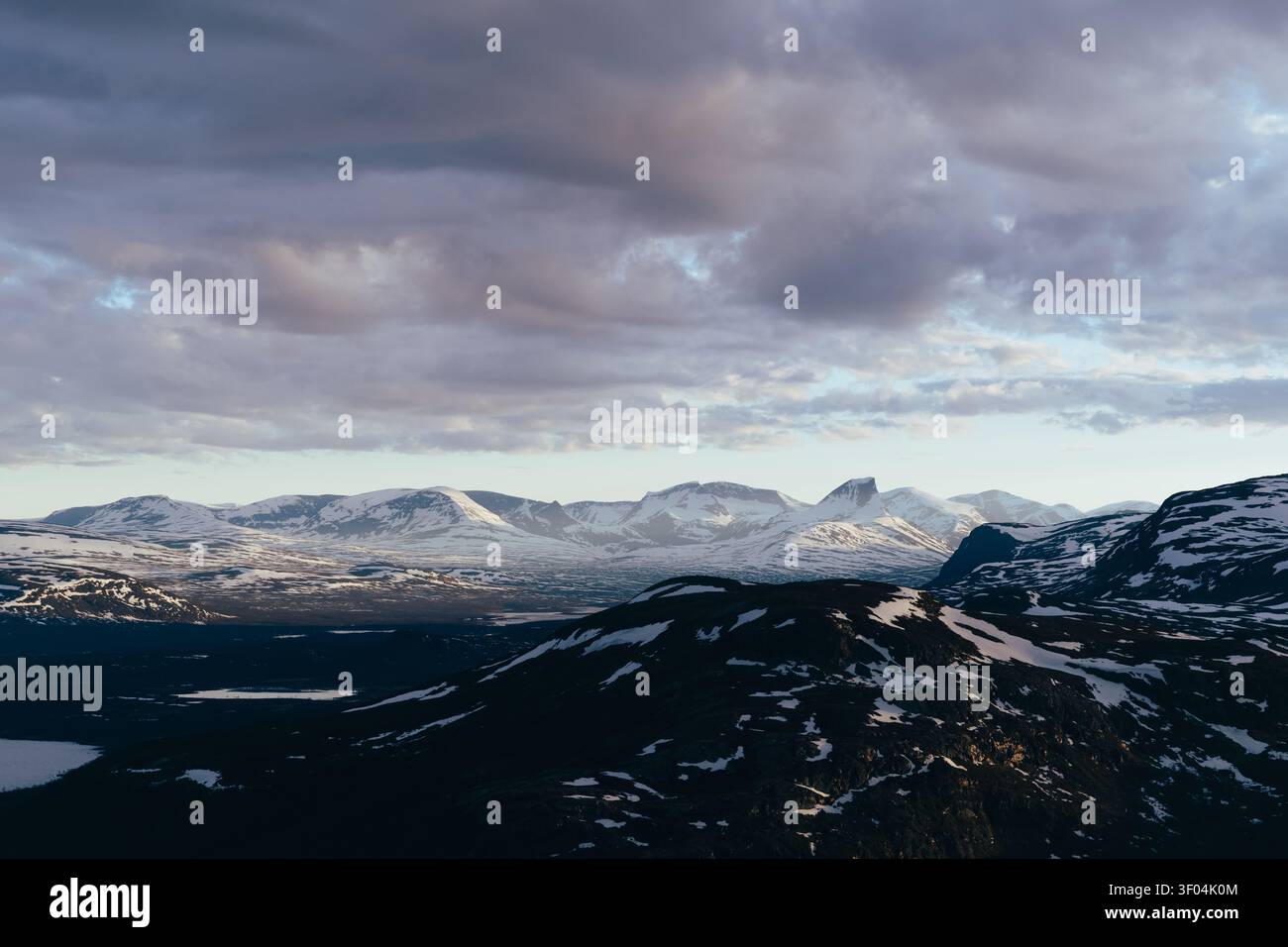 Majestic snow capped mountains under dramatic clouds Stock Photo