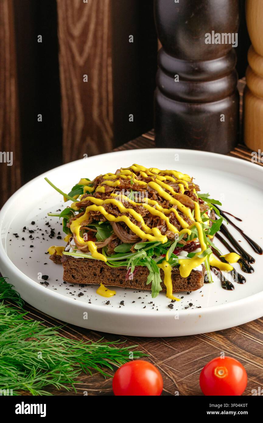 Gourmet open face sandwich with pulled meat and mustard Stock Photo