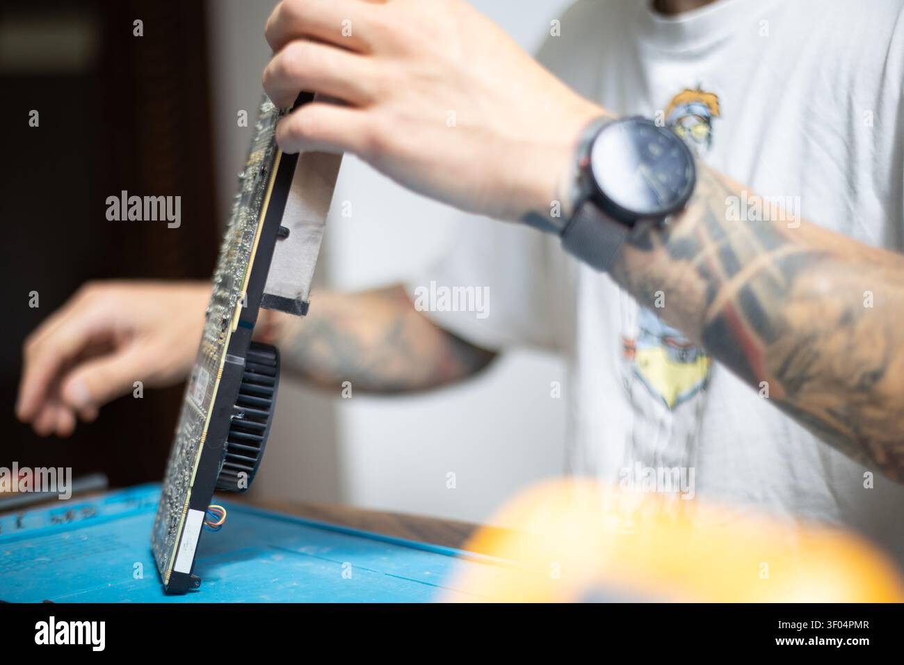 Technician works on computer hardware in a workshop during the day Stock Photo