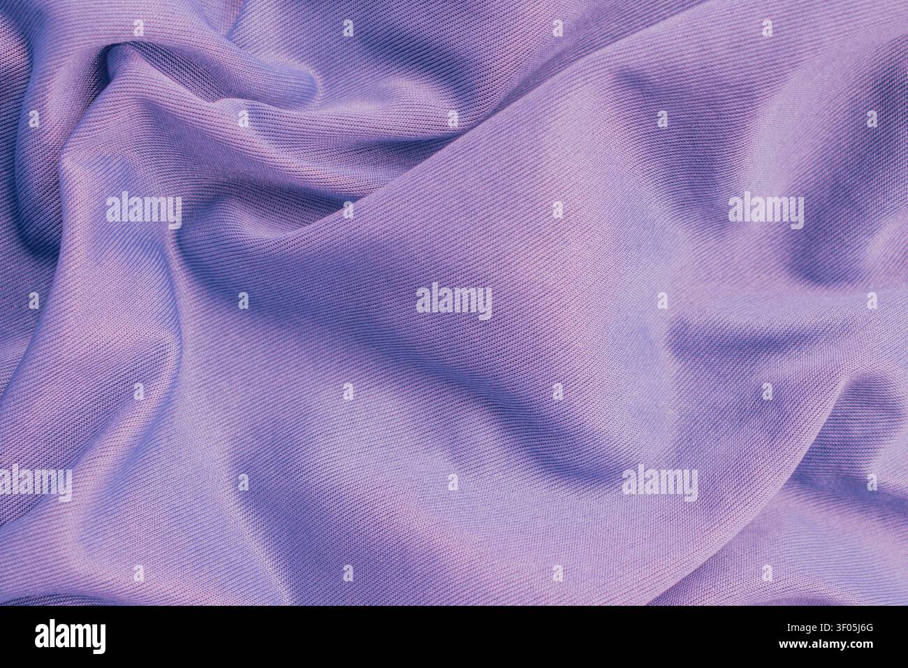 Horizontal macro top view of wrinkled mauve polyester fabric texture showing fine diagonal ribbed lines on smooth synthetic athletic apparel material Stock Photo