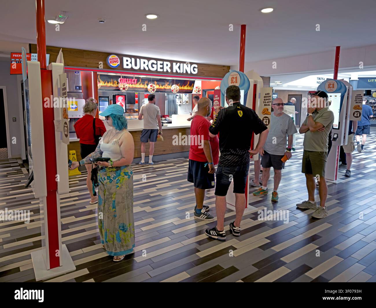 Customers use digital self-service ordering kiosks at Burger King inside Welcome Break Warwick Services on the M40 in Warwickshire, England, UK Stock Photo