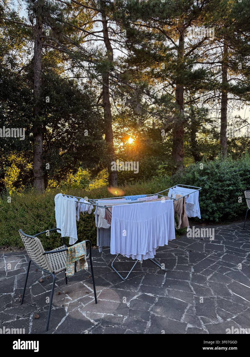 Laundry drying on rack outdoors at sunset Stock Photo
