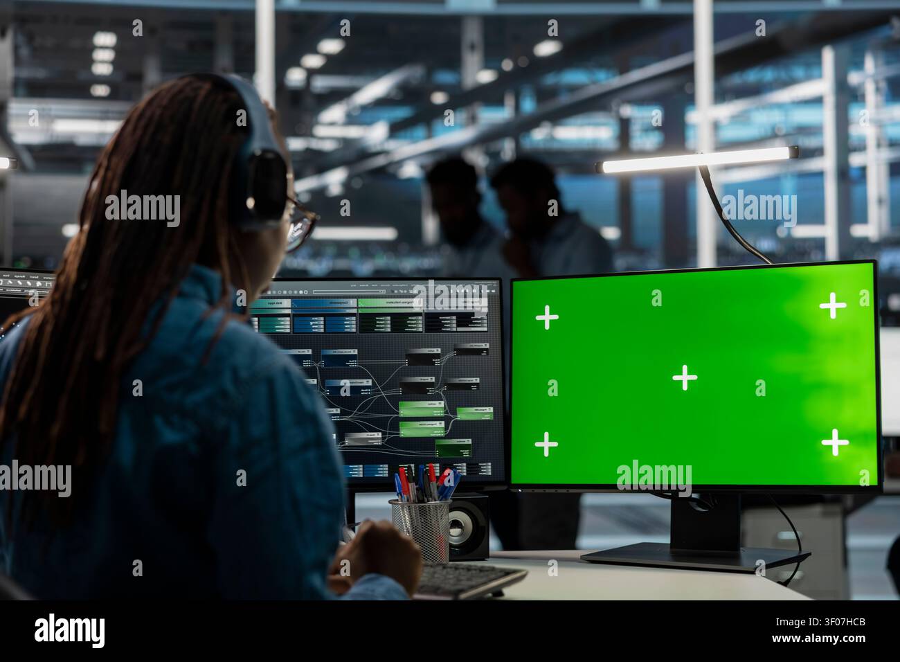 Data center administrator works with a chroma key computer, using an editable screen to repair technical issues. Stock Photo