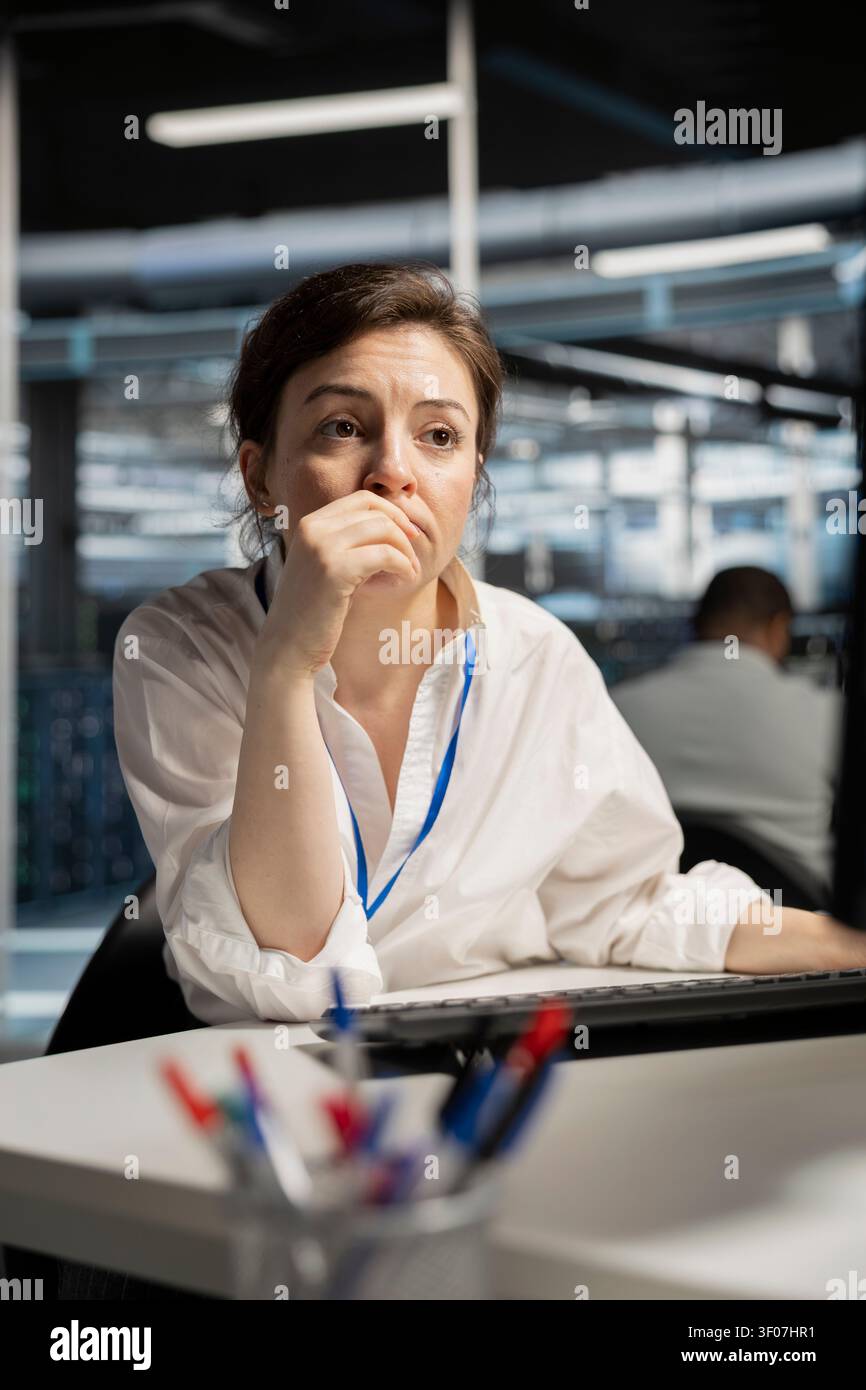 Computer scientist uses a desktop computer in a data center to run hardware diagnostics and maintain operational stability. Stock Photo