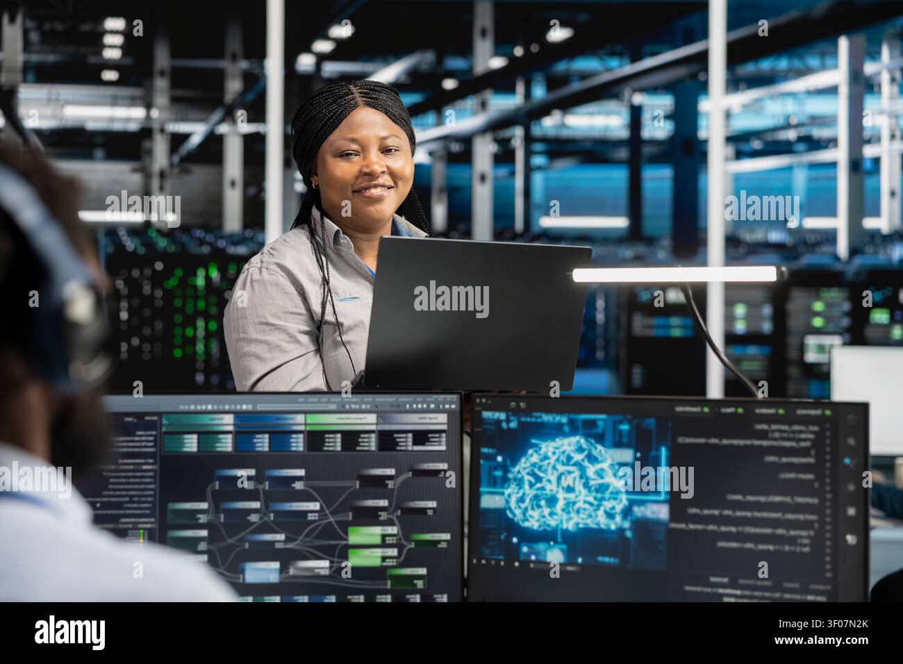Pleased data center software developer celebrates after configuring machine learning systems with AI technology in a data center. Stock Photo