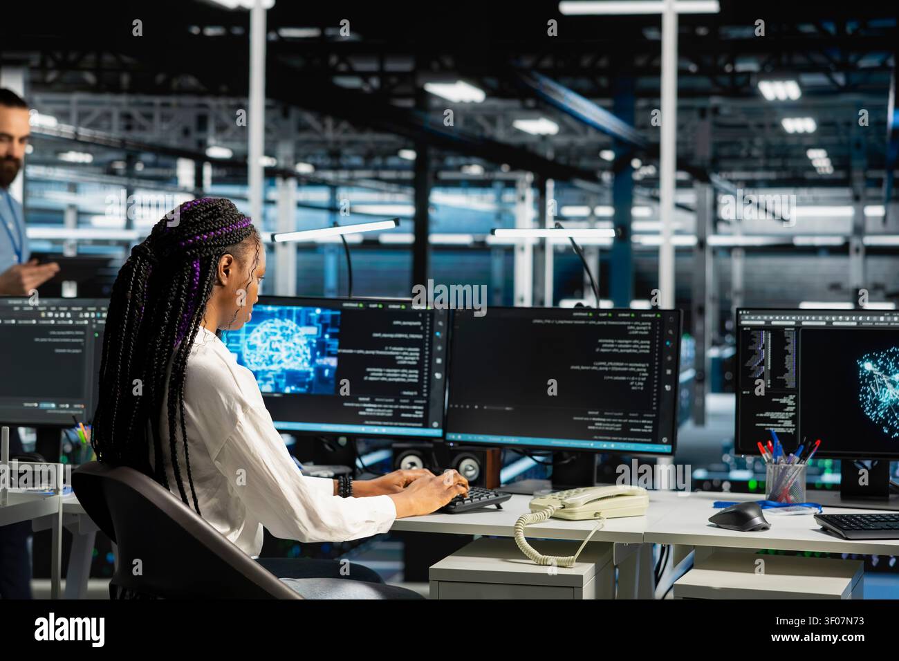 Software engineer working in server environment with hardware supporting data mining. Stock Photo