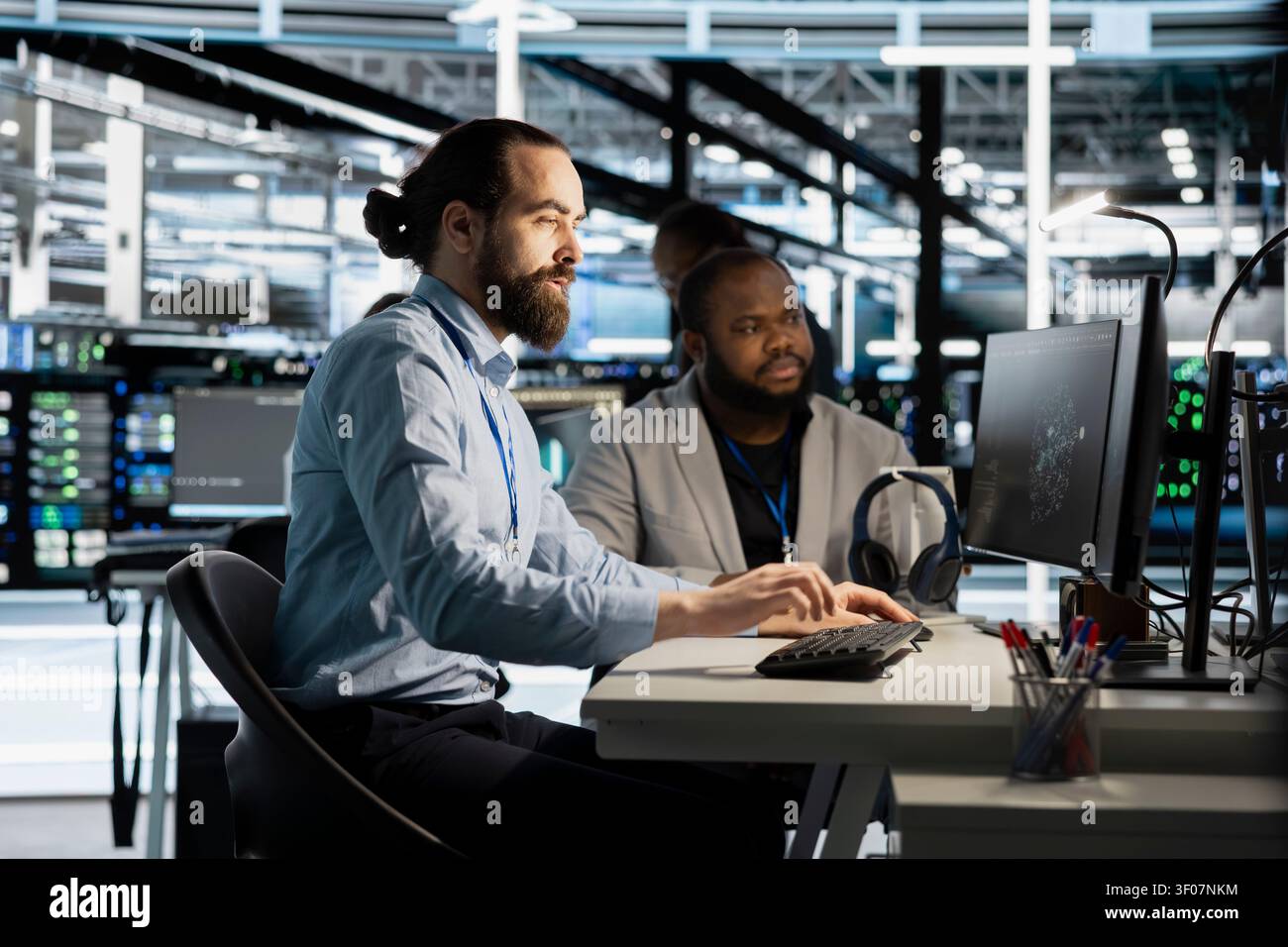 Team of programmers working with workstation in server environment, analyzing data. Stock Photo