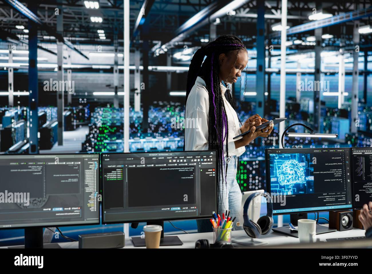 Coder coding in server facility, updating ML automation scripts. African American woman in server facility programming AI algorithms, debugging equipment racks. Stock Photo