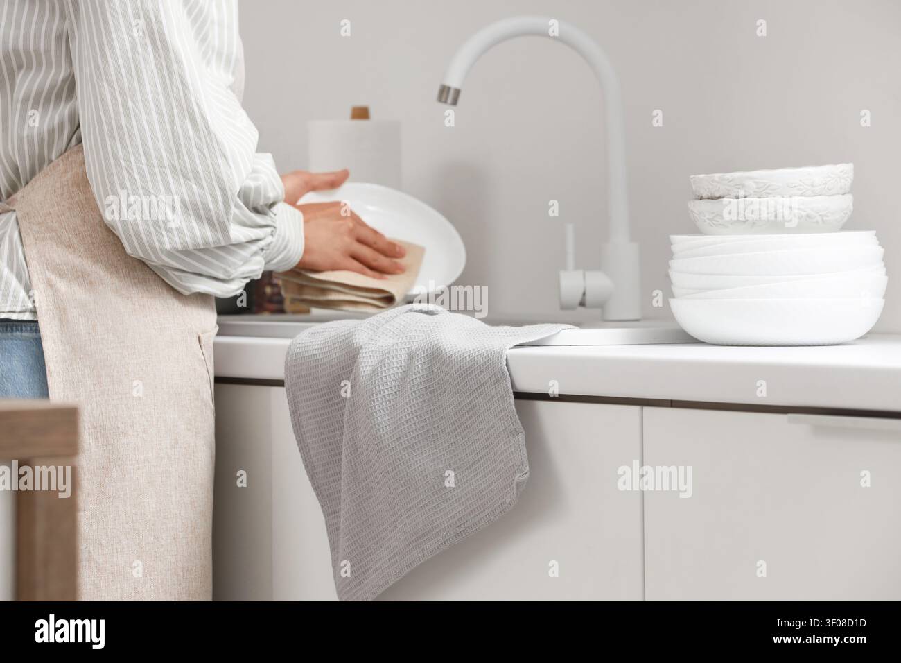 Person drying dishes in modern kitchen Stock Photo