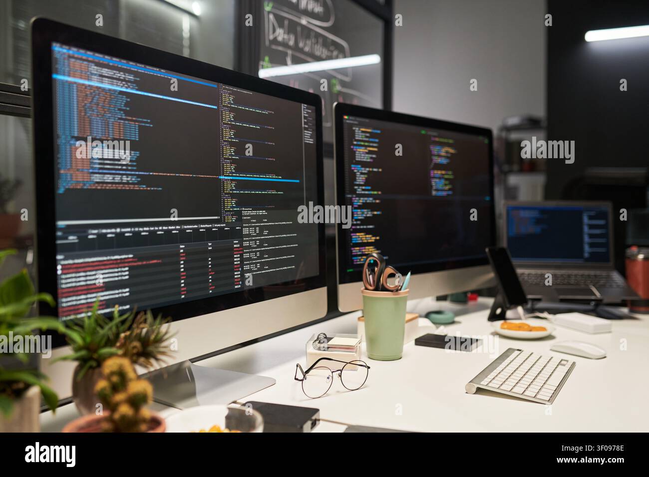 Software Development Workstation Displaying Code for Tech Team Stock Photo
