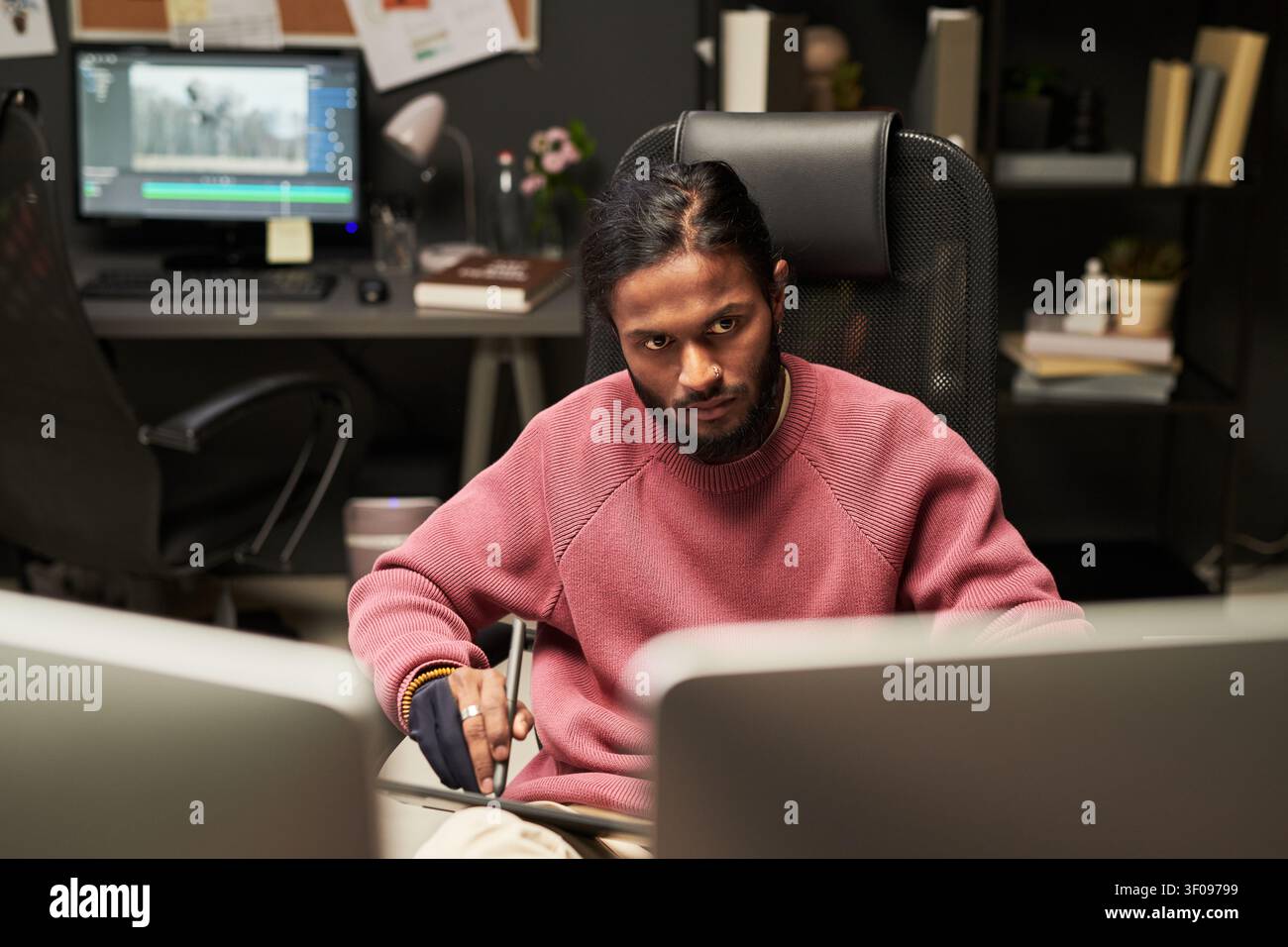 Young Man Editing Video Content in Creative Office Stock Photo