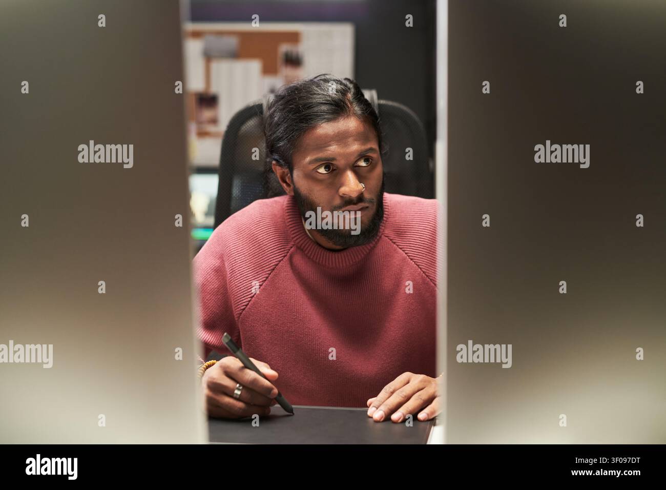 Indian Man Using Stylus While Working on Digital Design Project Stock Photo