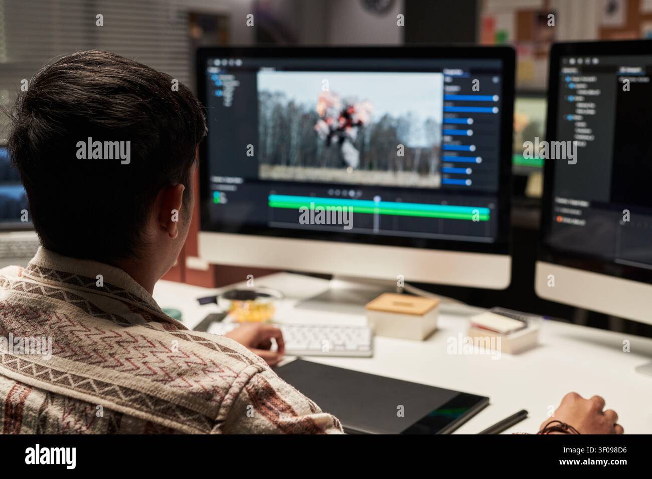 Man Editing Video Content on Desktop for Media Production Stock Photo