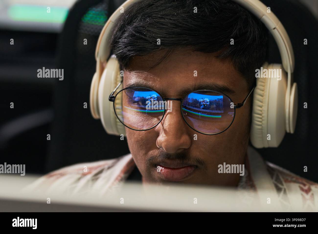 Asian Man Wearing Headphones While Gaming on Computer Stock Photo