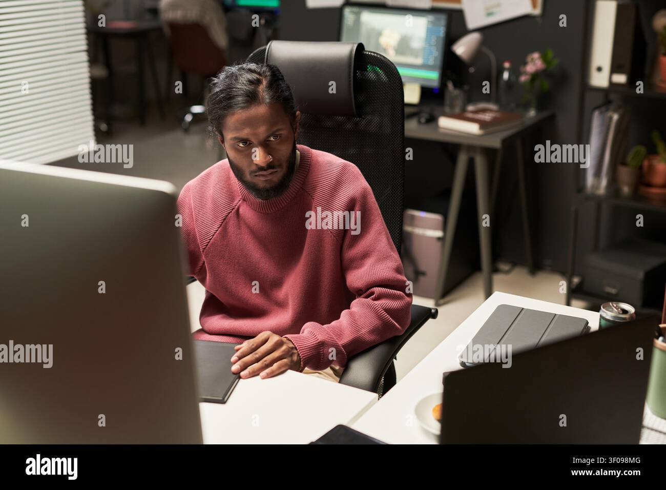 Indian Man Working at Computer in Creative Office Stock Photo