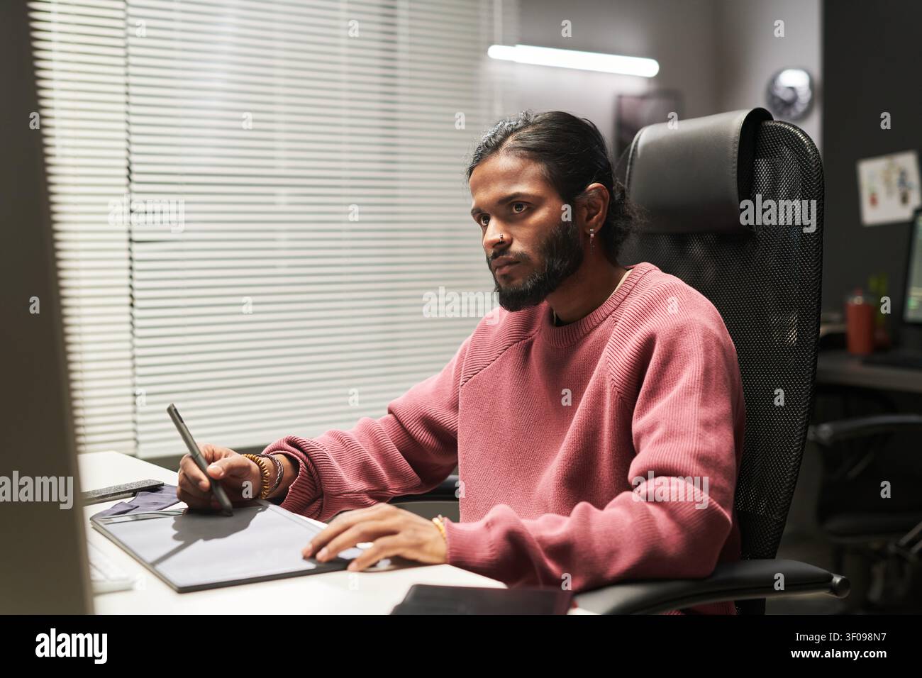 Indian Man Using Graphic Tablet for Creative Work Stock Photo