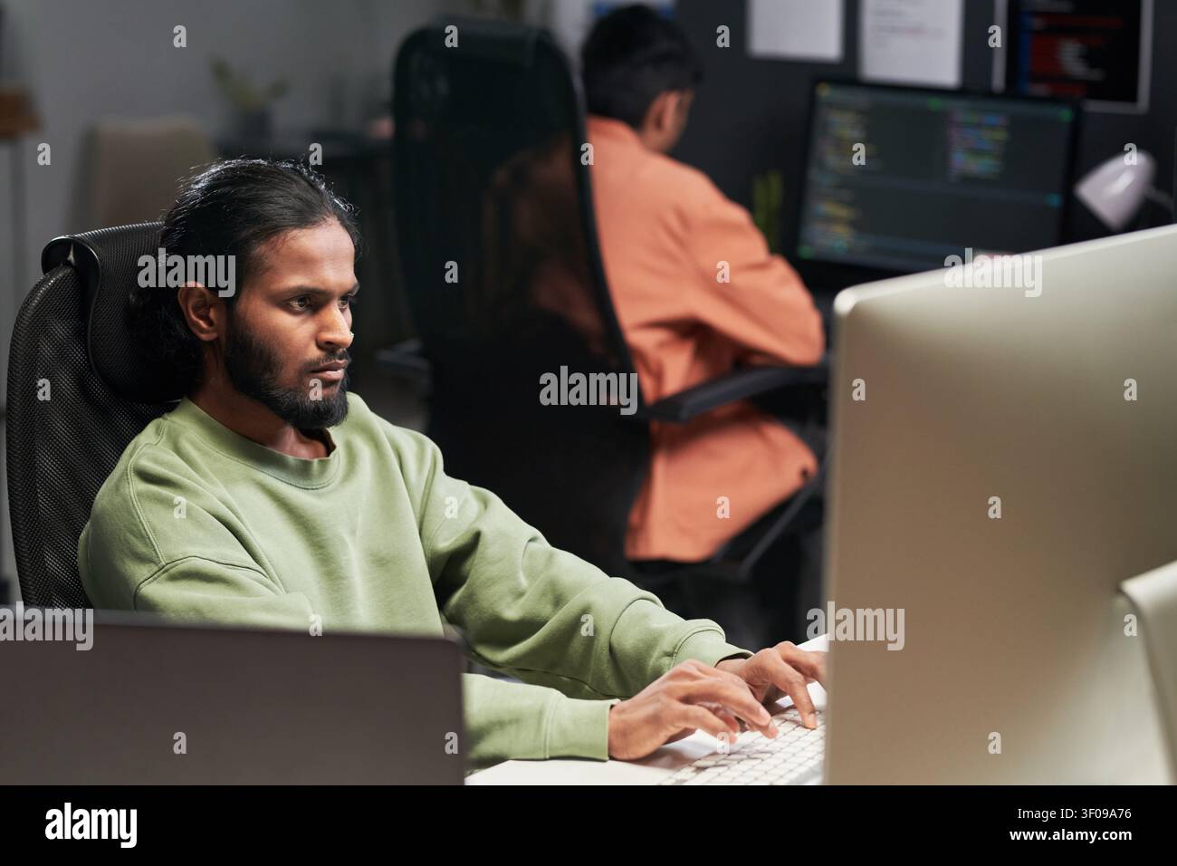 Man Coding at Desktop in Software Development Office Stock Photo