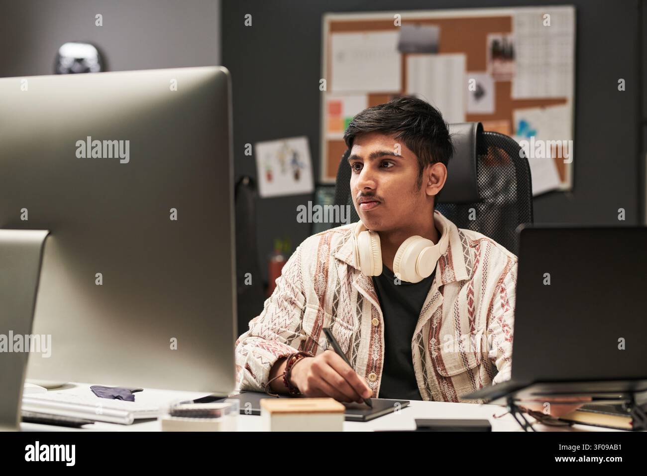 Asian Man Using Computer for Digital Design Work Stock Photo