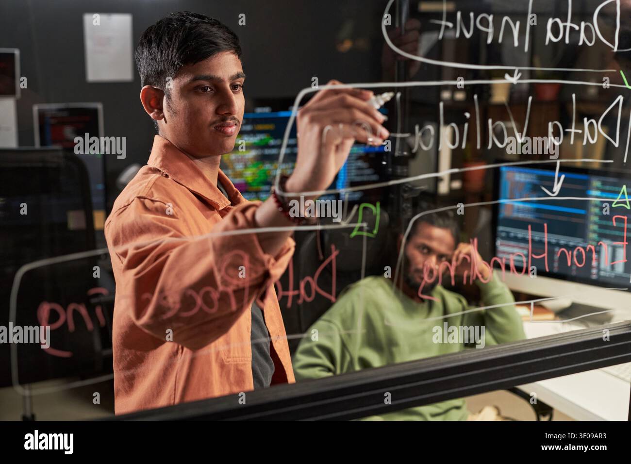 Asian Man Writing Data Flow Diagram for Software Development Stock Photo