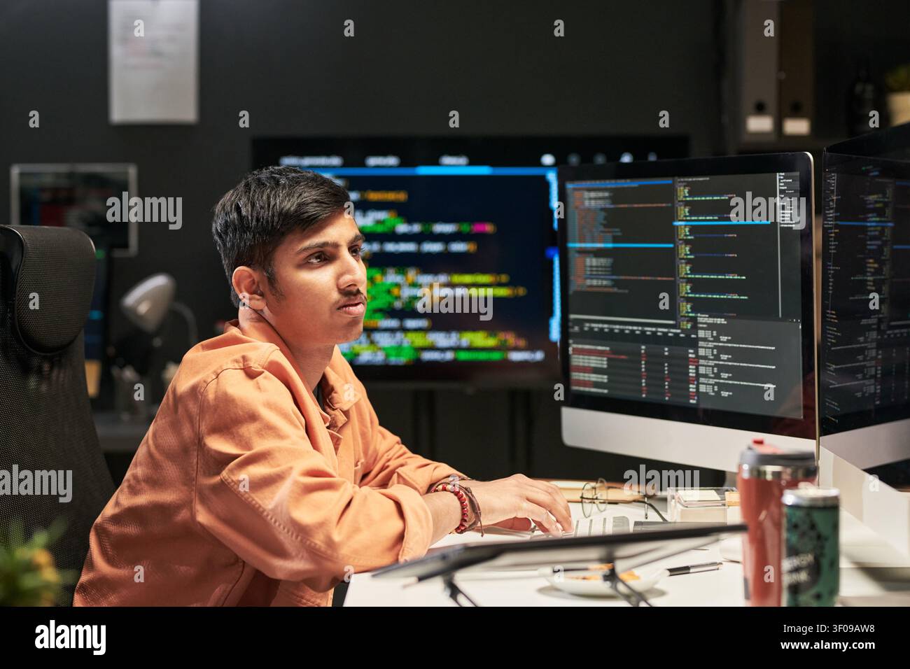 Young Developer Coding Software at Desk for Technology Startup Stock Photo