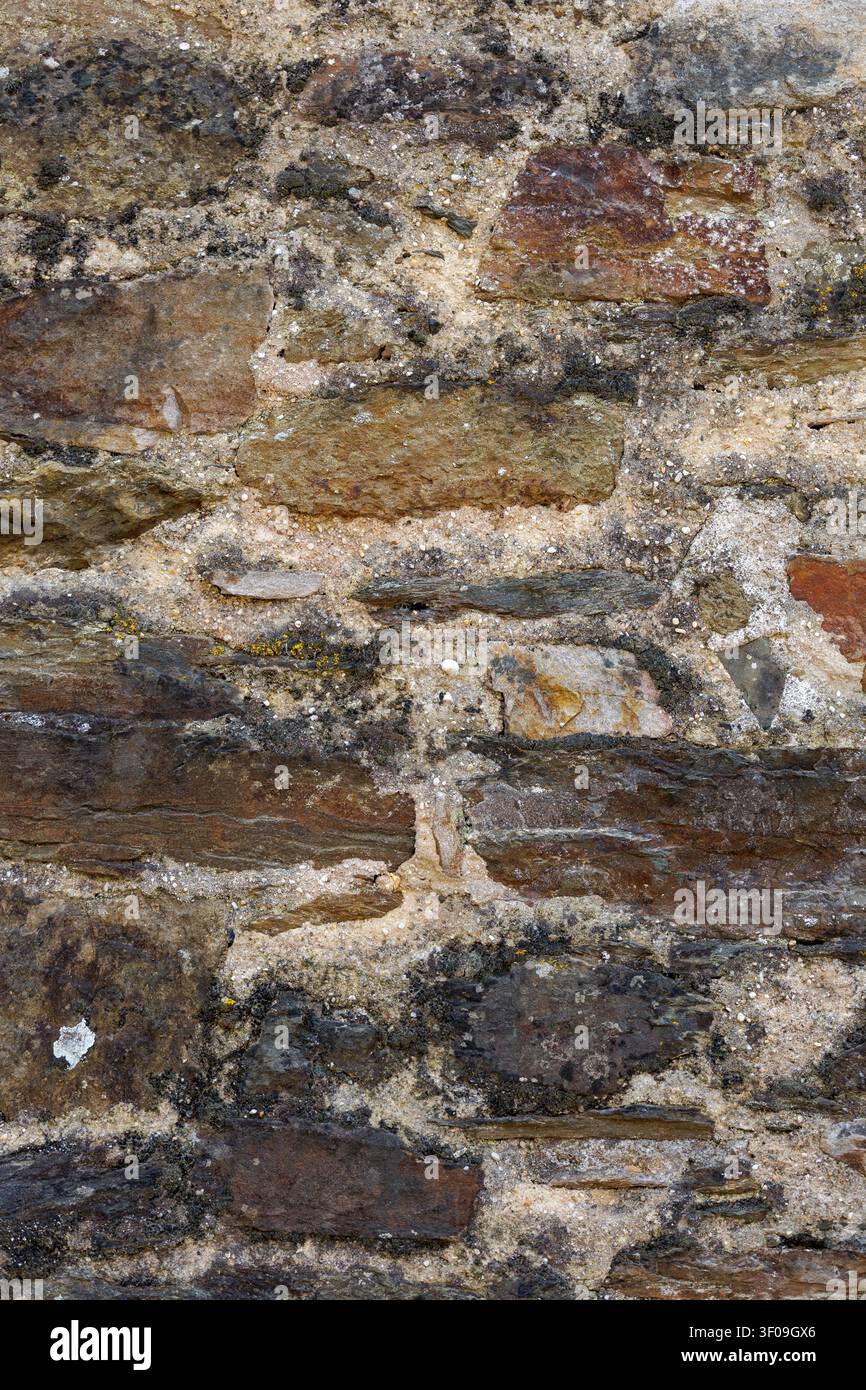 Weathered natural stone wall texture with rustic masonry pattern background Stock Photo