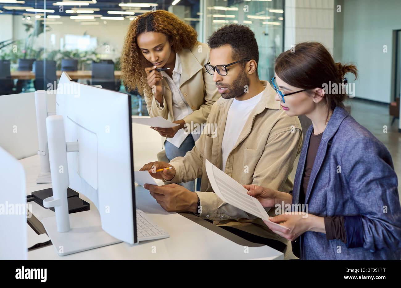 Diverse office team collaborating at computer during meeting planning discussion Stock Photo