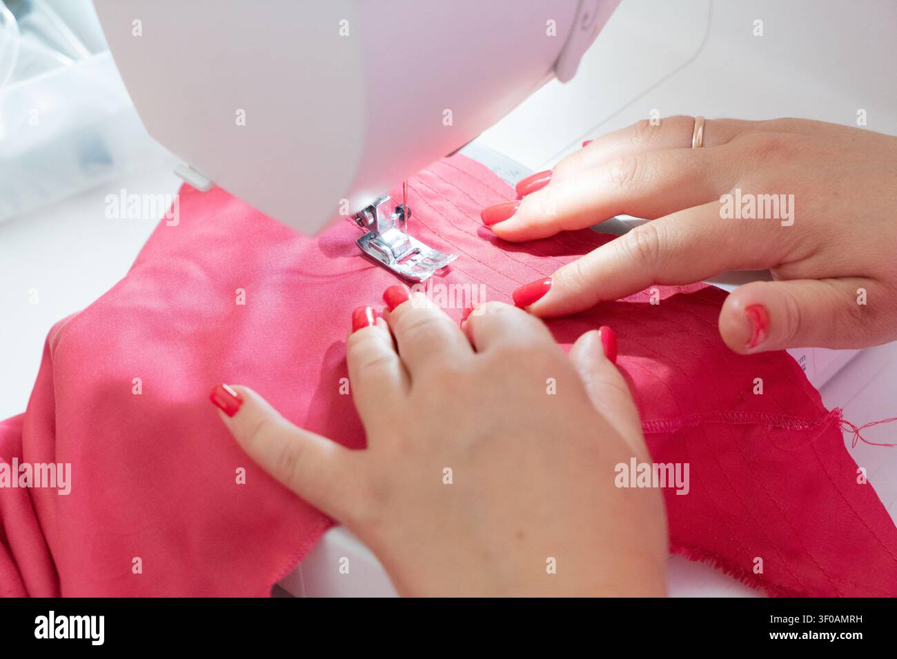 Sewing background with designers hands and sewing machine Stock Photo