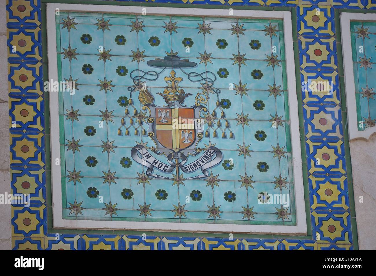 A flat lay macro shot of a traditional ceramic tile mosaic mural decoration on a building wall. The artwork displays complex geometric star patterns a Stock Photo