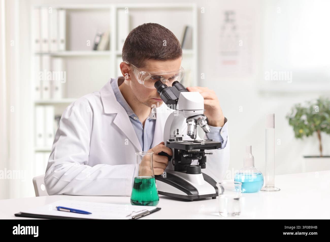 Laboratory scientist looking through microscope in an office Stock Photo