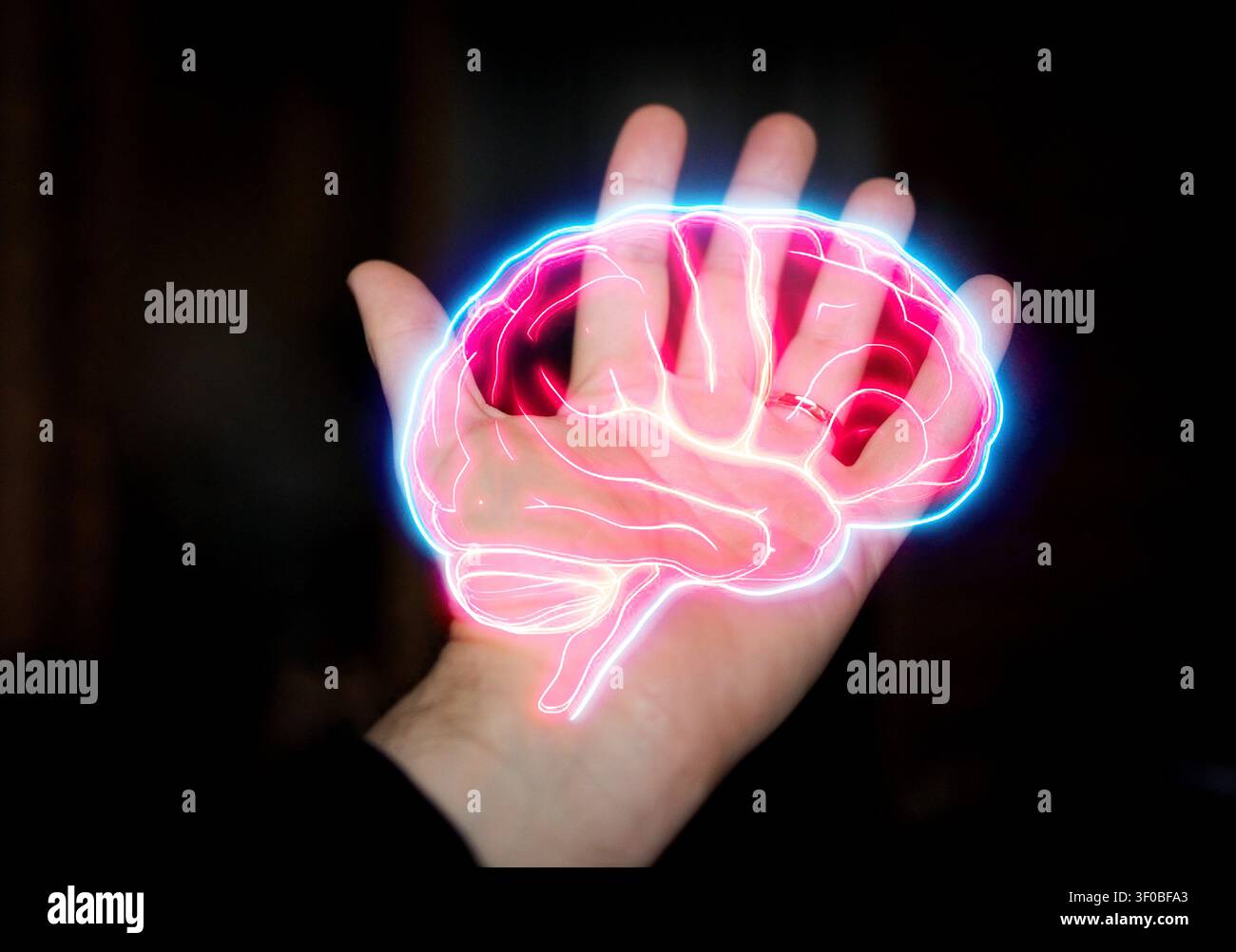 Human hand displays a glowing digital brain illustration with neon outlines, set against a dark background, representing technology and neuroscience t Stock Photo
