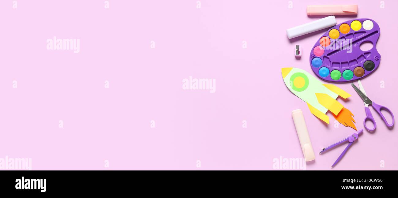 Colorful kids craft supplies with paper rocket on pink background Stock Photo