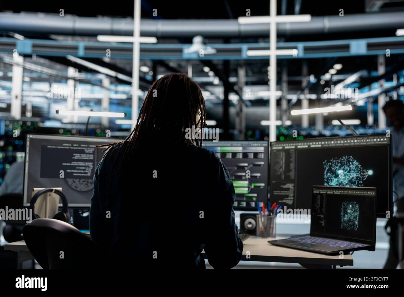 System operator uses a laptop computer in a data center to support failure detection and reliable server workflows. Stock Photo