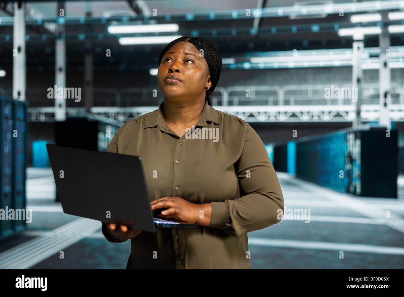 Admin working with notebook computer to do maintenance in server facility with setup helping companies stay connected. Stock Photo