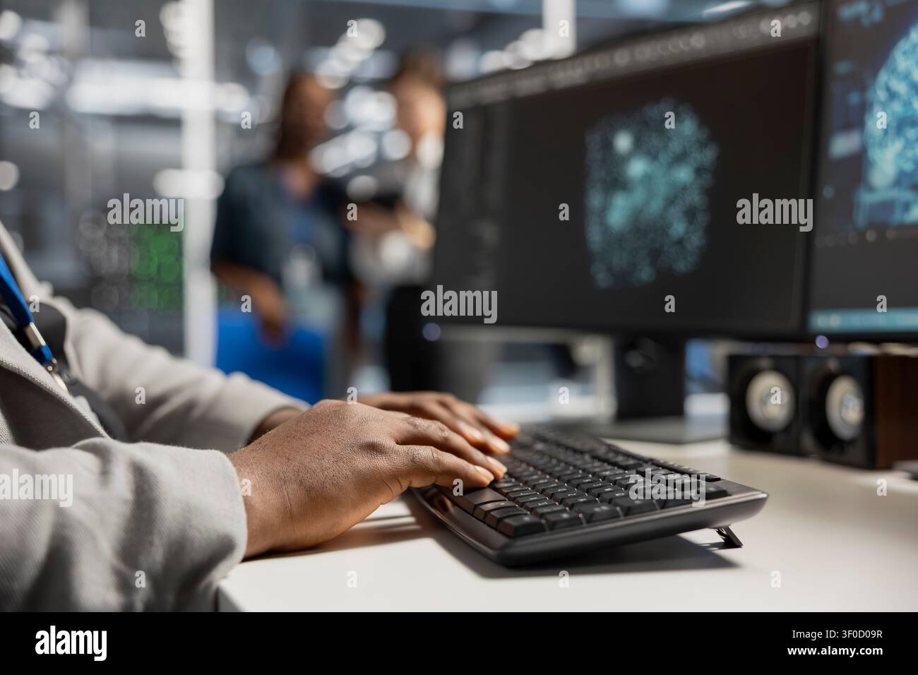 Computer scientist uses a desktop computer in a data center to manage AI simulation and optimize server infrastructure. Stock Photo