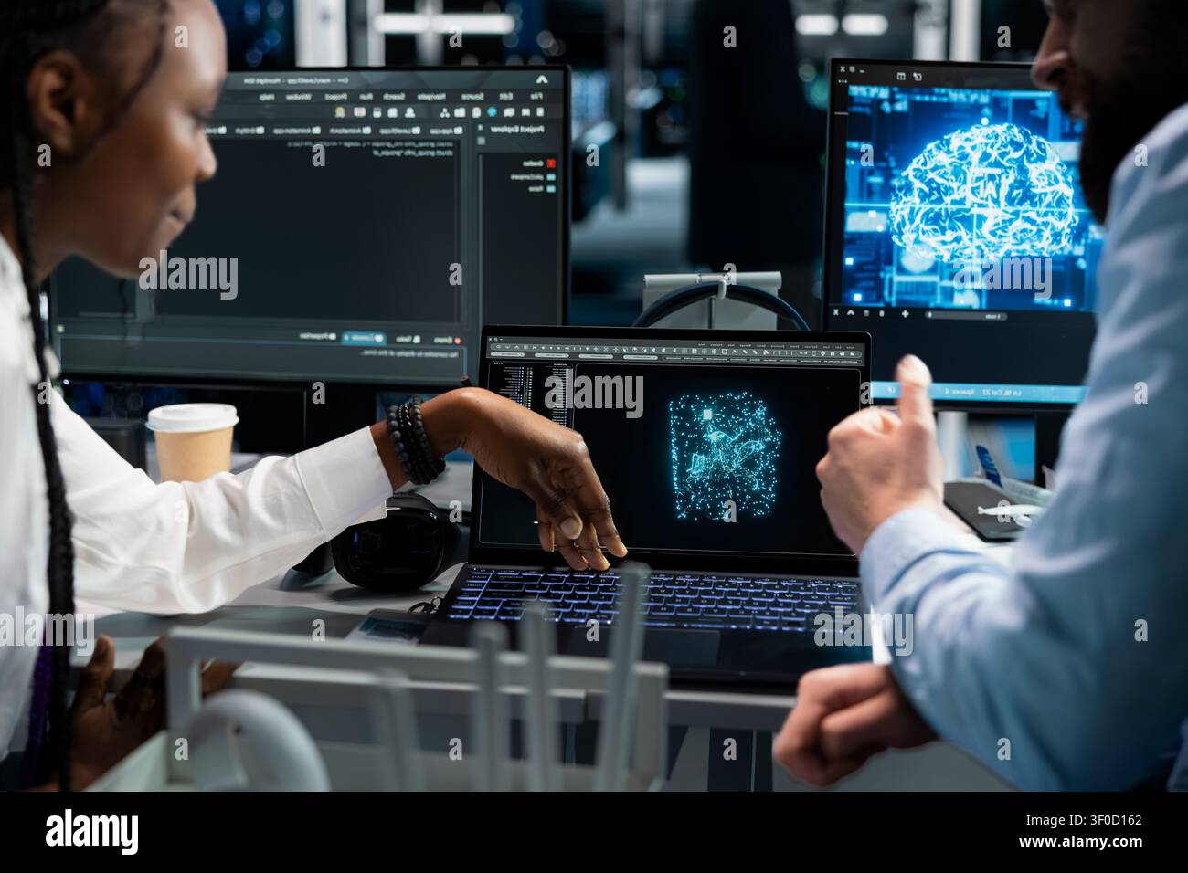 Lead software programmer and female technical specialist in computing facility updating AI automation scripts, while and african american woman programming AI algorithms at desk. Stock Photo