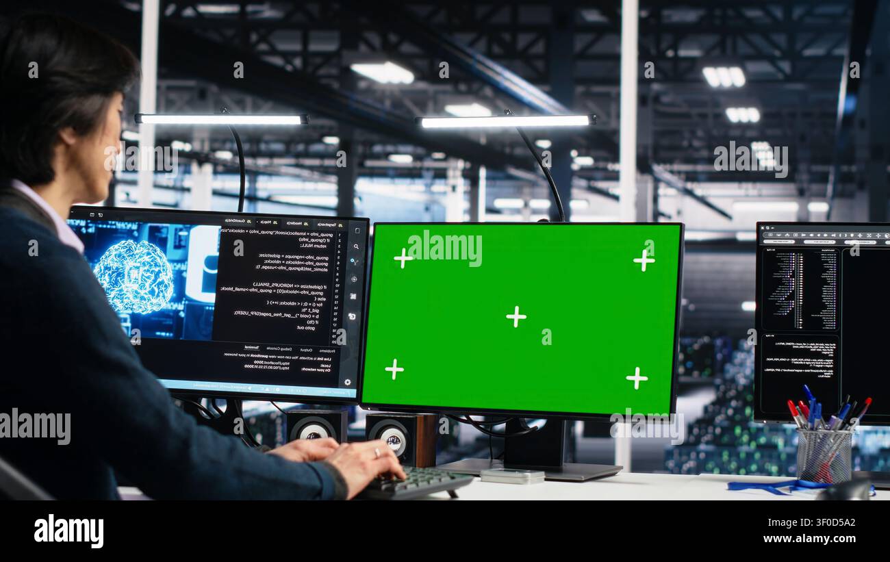 Technician programs on a green screen computer in a data center with generative AI assistance. Stock Photo