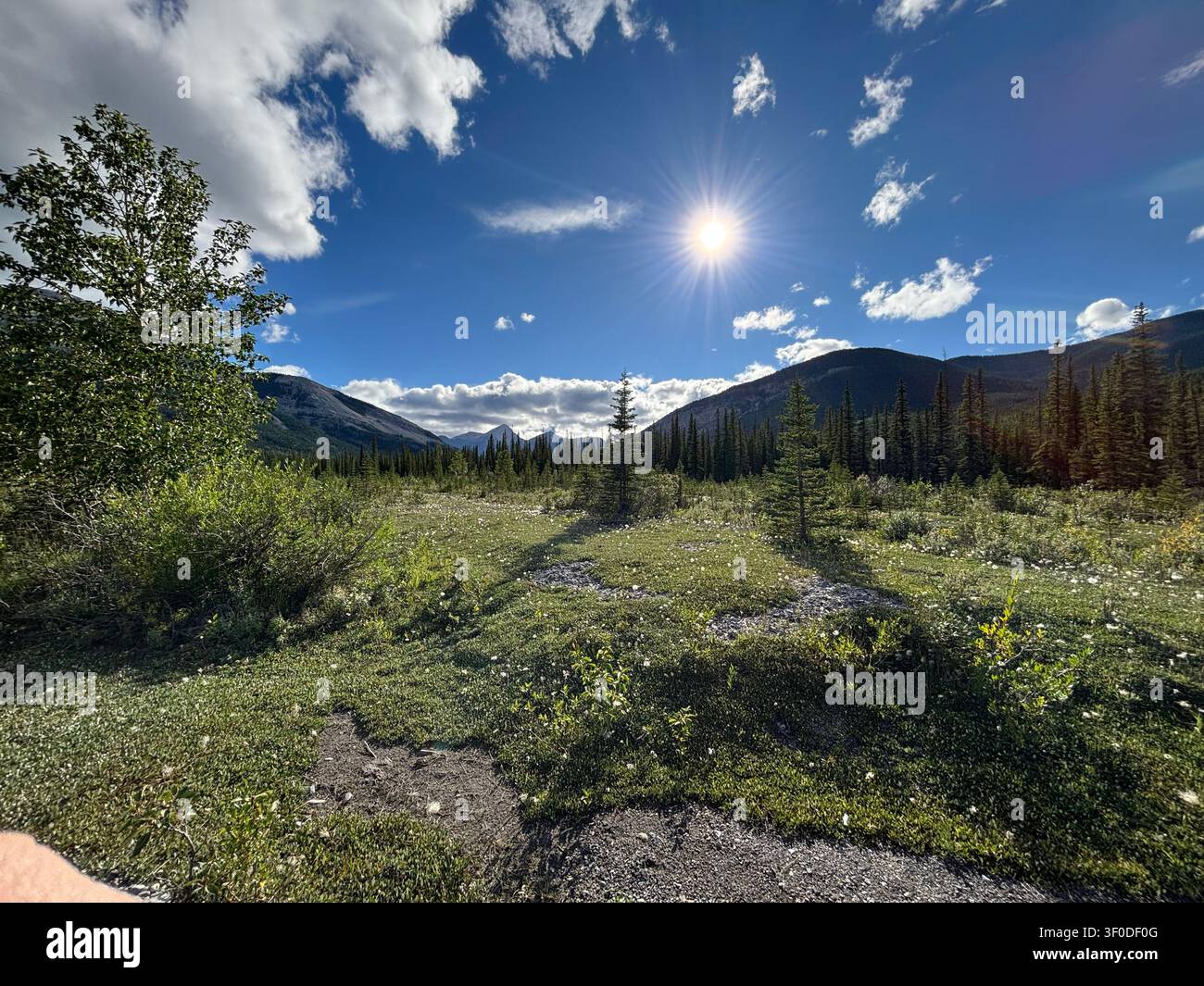 Sunlight breaks through light clouds over the peaks of Kananaskis Country, Alberta, Canada. Stock Photo