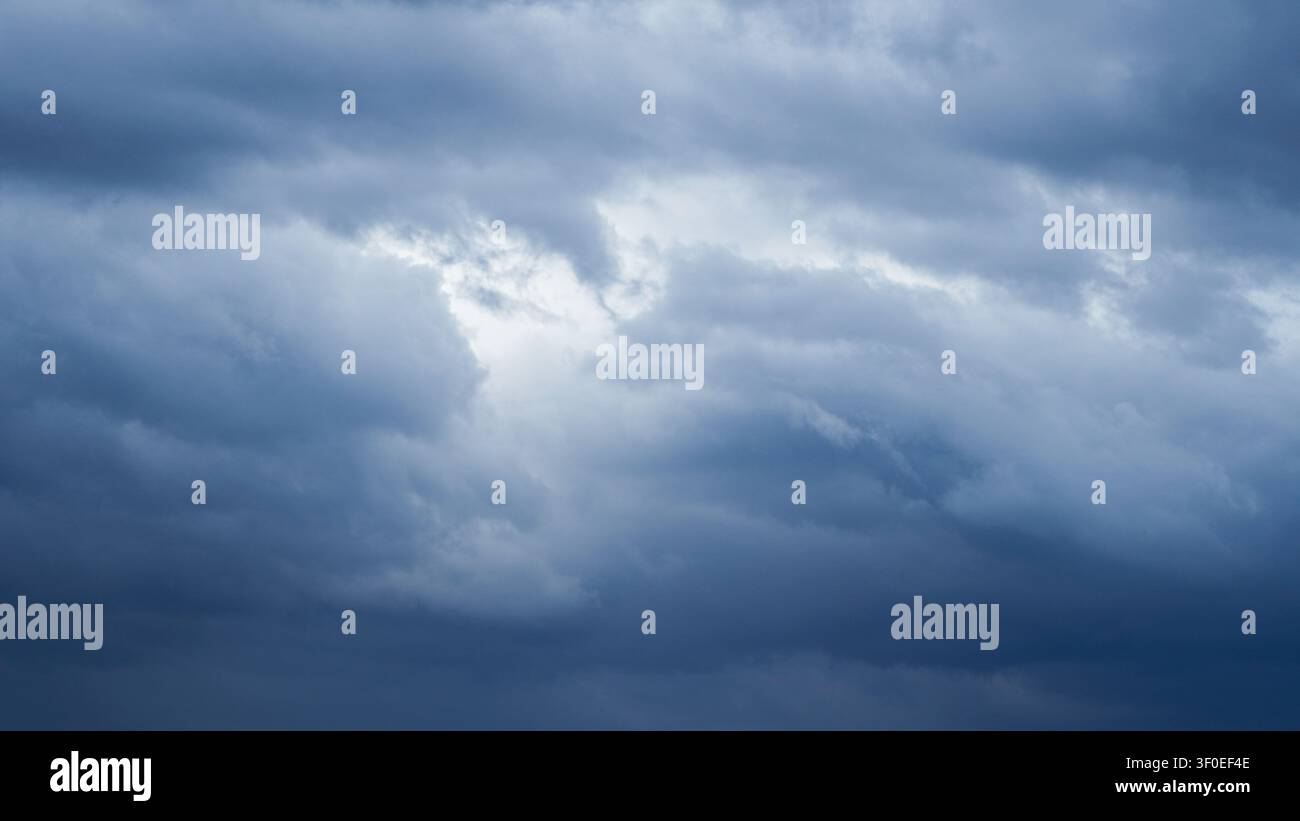 Dramatic overcast sky with dense dark blue clouds gathering before a rainstorm Stock Photo