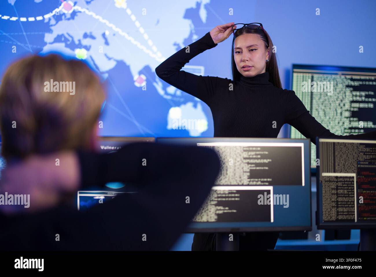 Cybersecurity professionals analyzing real-time threat data in a control room setting Stock Photo