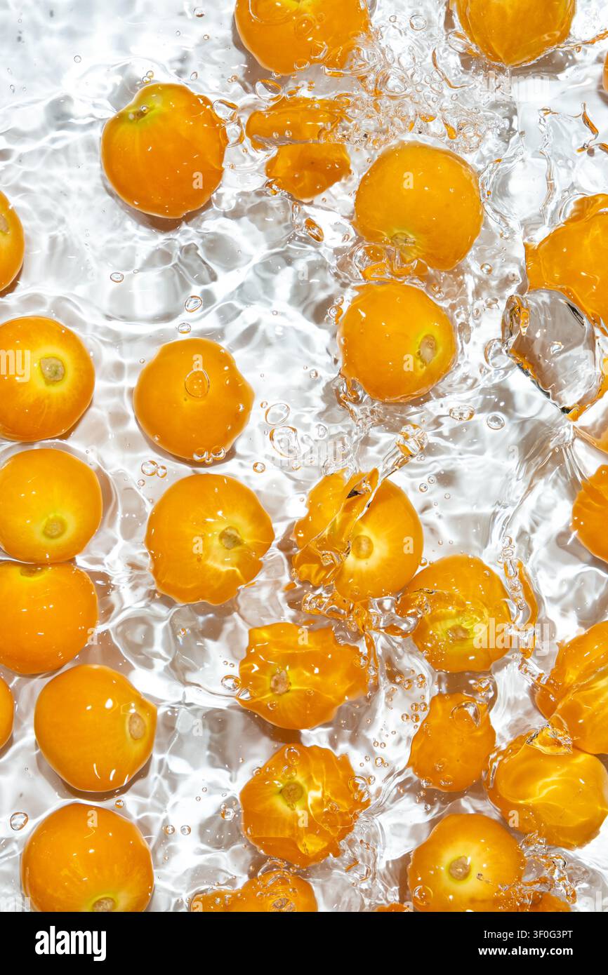 Fresh physalis berries washing in clean water with splashes Stock Photo