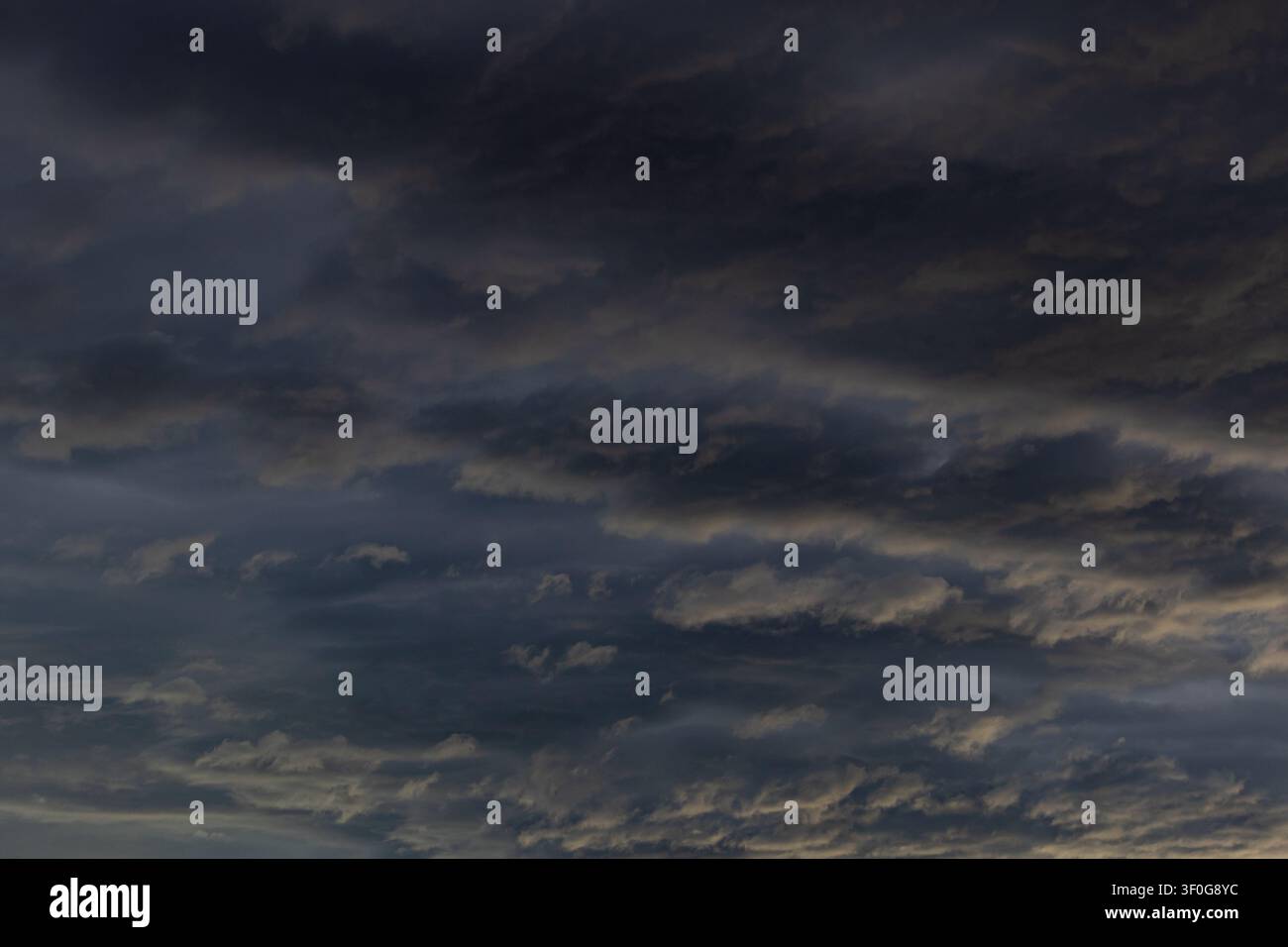 Sunlit stormy evening sky with dramatic banked clouds Stock Photo