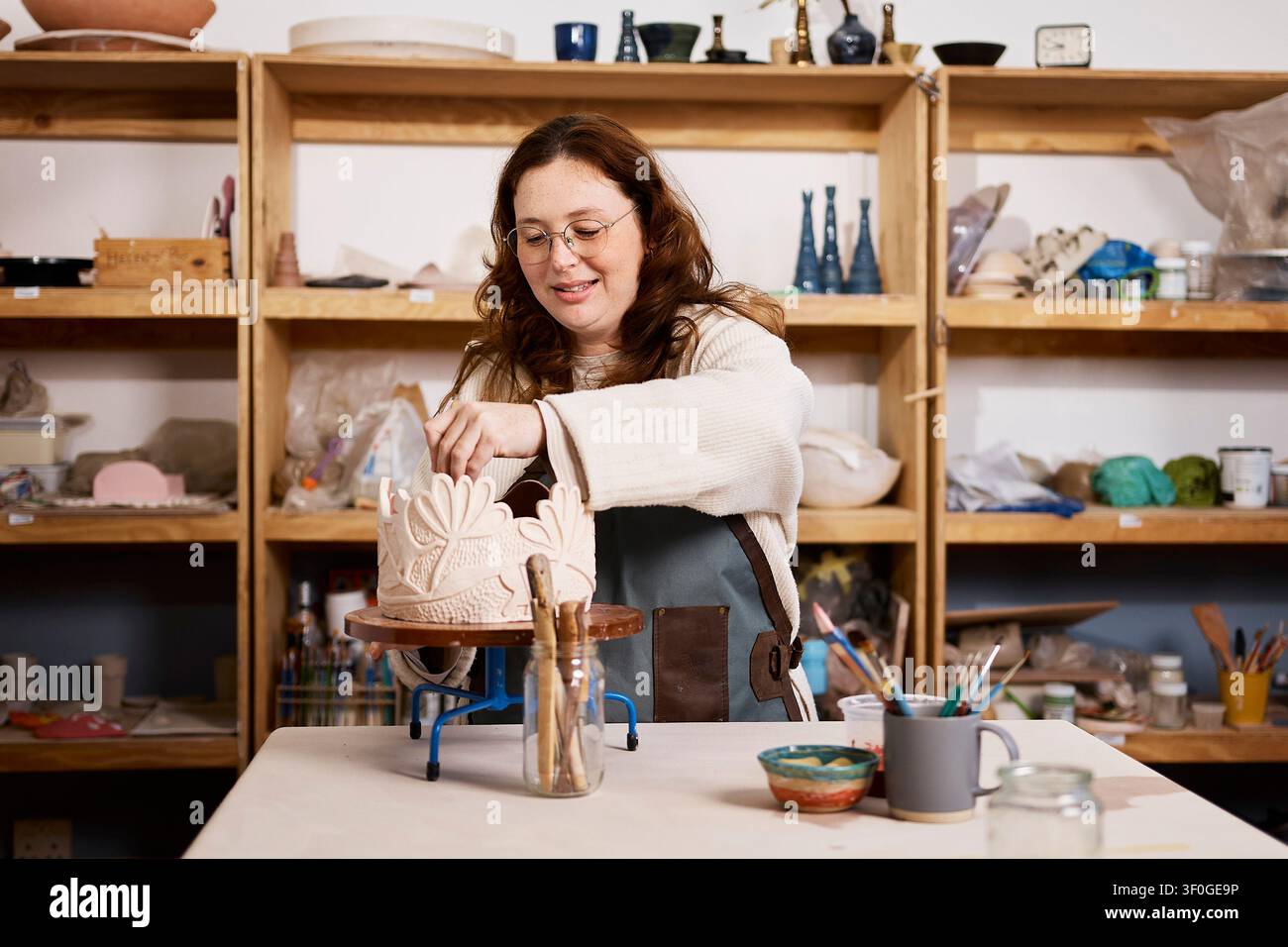 Female Ceramic Artist Working on Decorative Pottery in a Small Business Pottery Studio Stock Photo